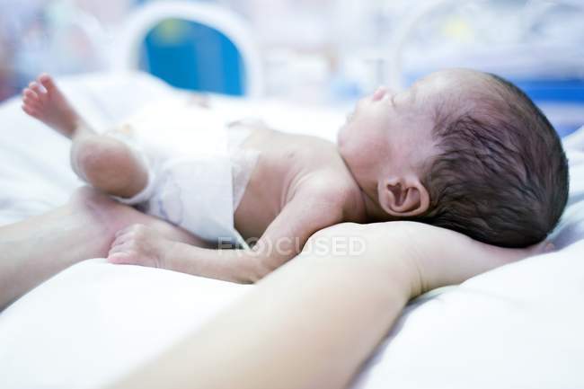 Primer plano de la enfermera que sostiene al bebé prematuro . - foto de stock