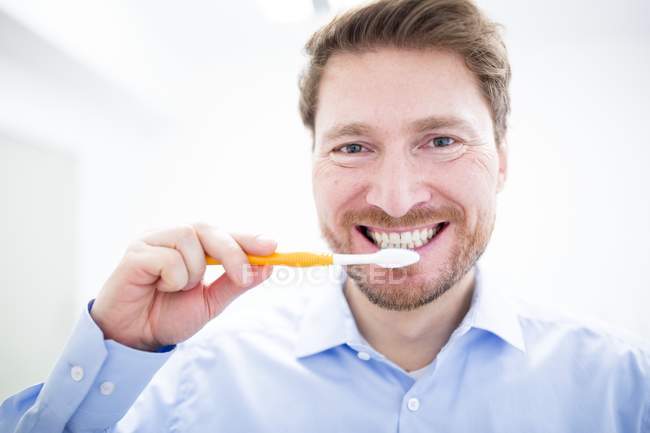Mitte erwachsener Mann beim Zähneputzen, Porträt. — Stockfoto