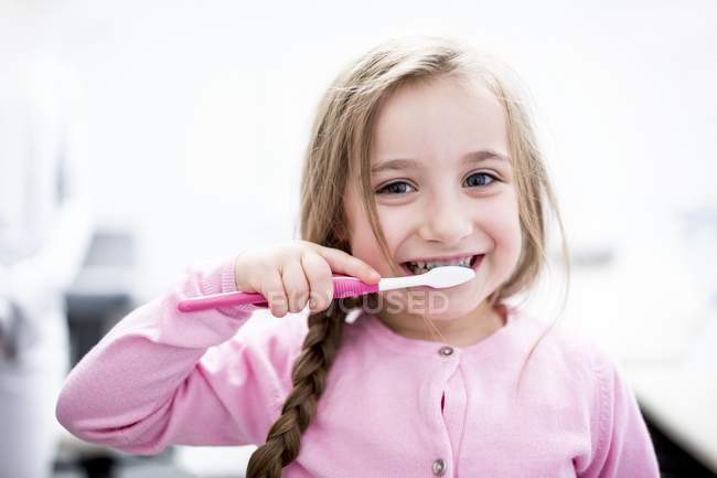 Portrait of little girl brushing teeth. — Stock Photo