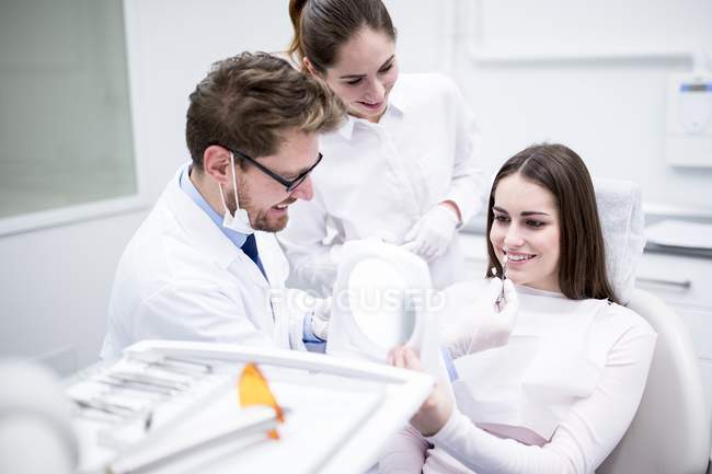 Odontólogos y pacientes seleccionando carillas dentales . - foto de stock