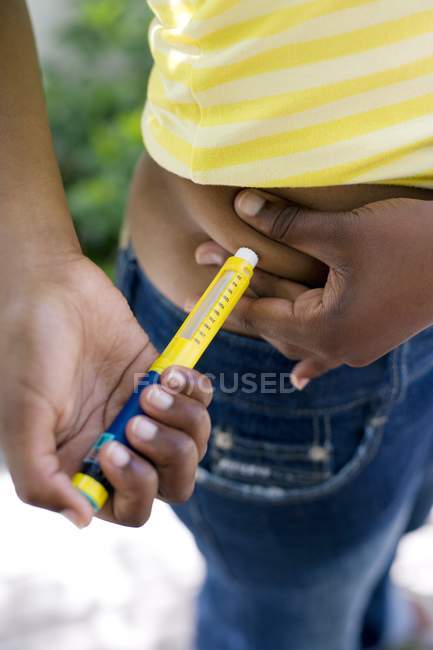 Diabetic teenage girl making injection with hormone insulin in abdomen. — Stock Photo