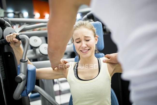Woman crying in pain while exercising in gym. — Stock Photo