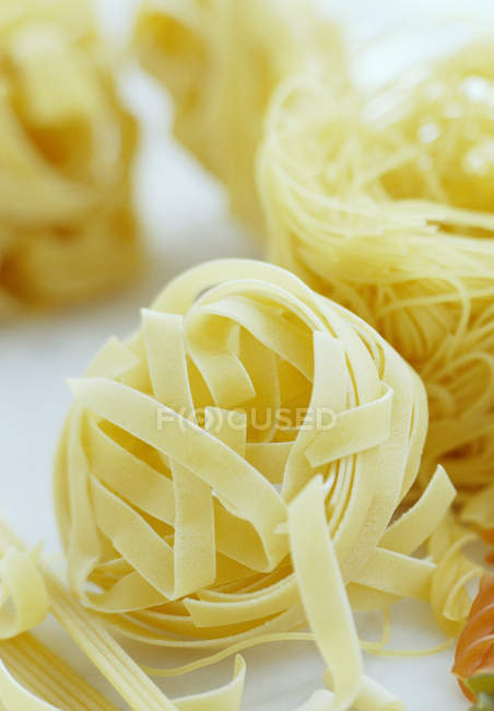 Dried tagliatelle pasta ribbons, close-up. — Stock Photo