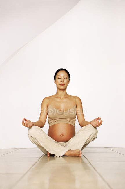 Donna incinta in posa yoga seduta . — Foto stock