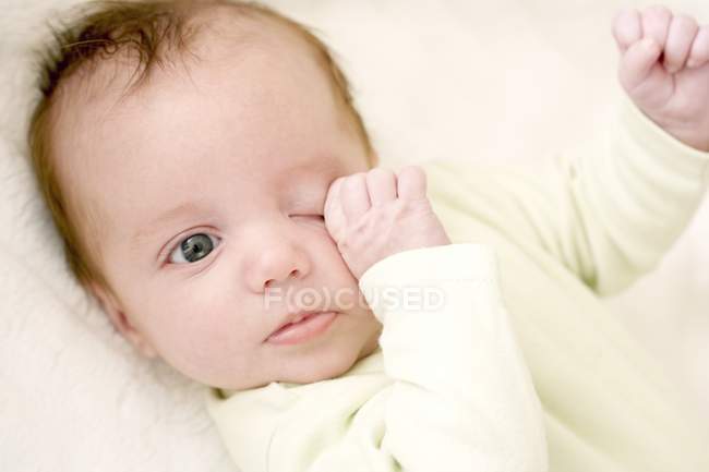 Tired baby girl rubbing eyes. — Stock Photo