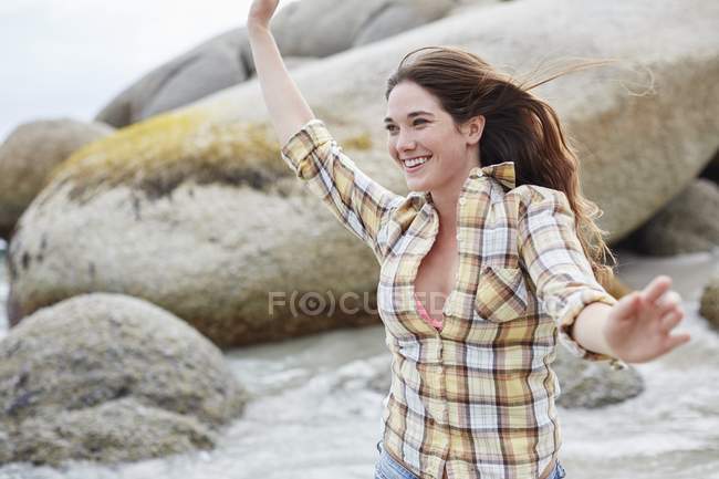 Молода жінка на пляжі з простягнутими руками . — стокове фото
