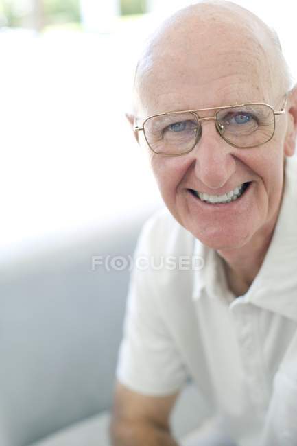 Retrato de homem idoso feliz em óculos clássicos olhando na câmera — Fotografia de Stock