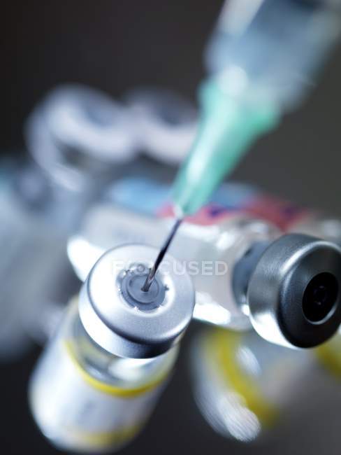 Visão de perto da agulha inserida no frasco para injetáveis da vacina . — Fotografia de Stock