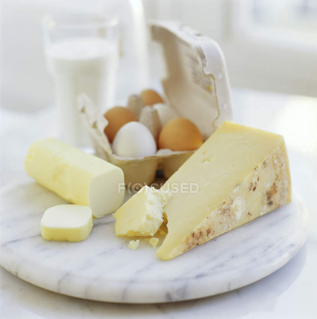 Vista de cerca de huevos y queso sobre tabla de madera . - foto de stock