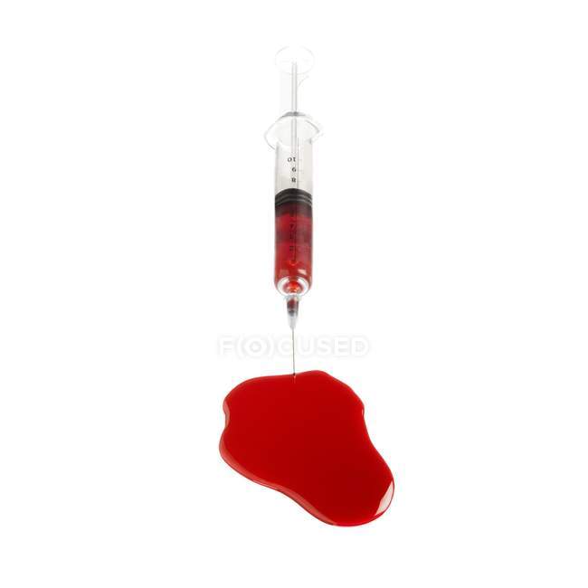 Syringe with spilled blood on white background. — Stock Photo
