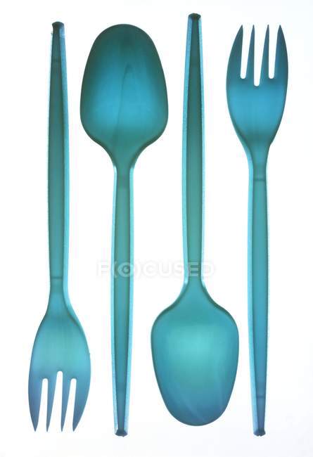 Cucharas y tenedores de plástico azul sobre fondo blanco . - foto de stock