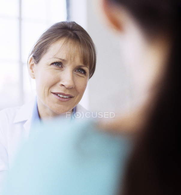 Médecin généraliste parlant à une jeune patiente
. — Photo de stock
