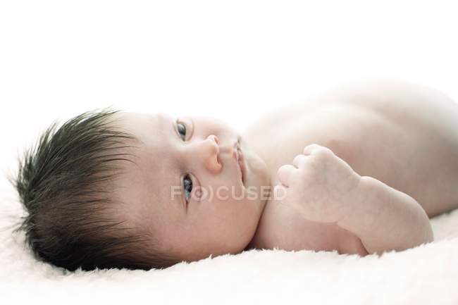 Newborn baby girl lying on white blanket. — Stock Photo