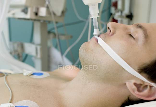 Unconscious man in intensive care ward at hospital. — Stock Photo