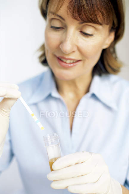 Krankenschwester hält Urinanalyse-Testergebnisse in der Hand. — Stockfoto