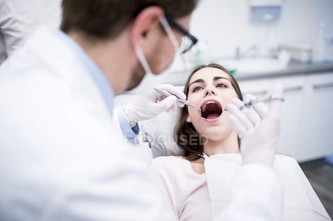 Dentist giving anesthesia to patient while dental surgery. — Stock Photo
