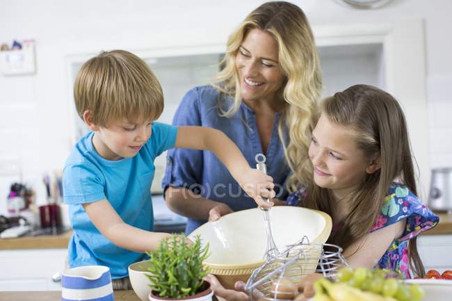 Mãe com filho e filha cozinhar na cozinha . — Fotografia de Stock