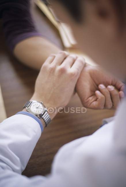 Doctor measuring patient pulse rate. — Stock Photo