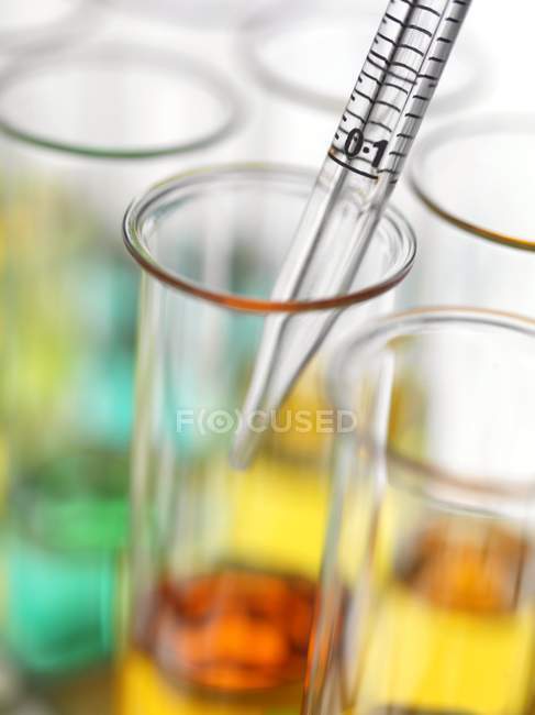 Primer plano de pipeteo de líquidos coloridos en tubos de ensayo
. - foto de stock