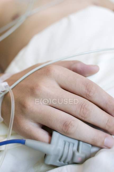Blood oxygen monitor on finger of patient in intensive care ward, close-up. — Stock Photo