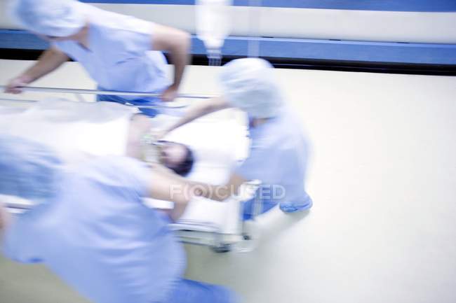 Надзвичайних команда, штовхаючи лікарні Герні з пацієнтом в коридорі. — стокове фото