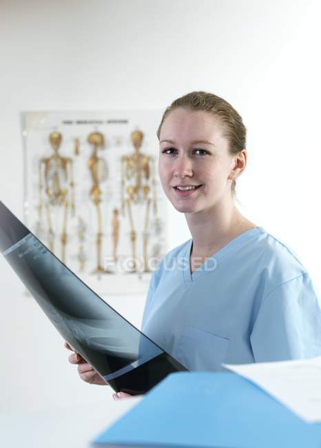 Médico segurando raio-X na clínica e olhando na câmera . — Fotografia de Stock