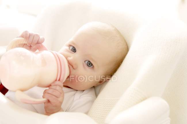 Bebê menina beber leite de garrafa. — Fotografia de Stock