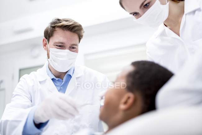 Modell veröffentlicht. Zahnarzt untersucht Patient mit seiner Hilfe. — Stockfoto