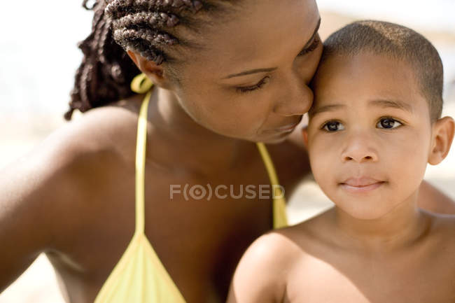 Madre e figlio abbracciare in spiaggia . — Foto stock