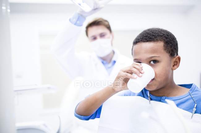 Porträt eines Jungen, der Wasser in der Klinik trinkt. — Stockfoto
