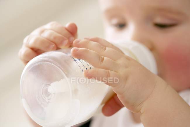 Retrato de menino bebendo leite de mamadeira . — Fotografia de Stock