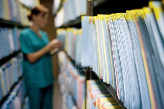 Krankenschwester überprüft Krankenakte im Abstellraum. — Stockfoto