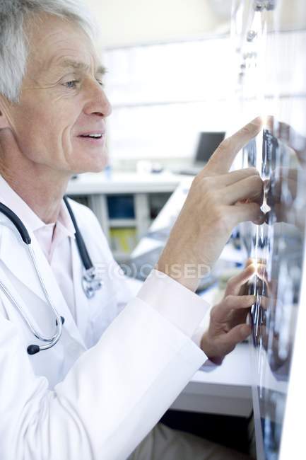 Senior radiologist studying CT scans in hospital. — Stock Photo