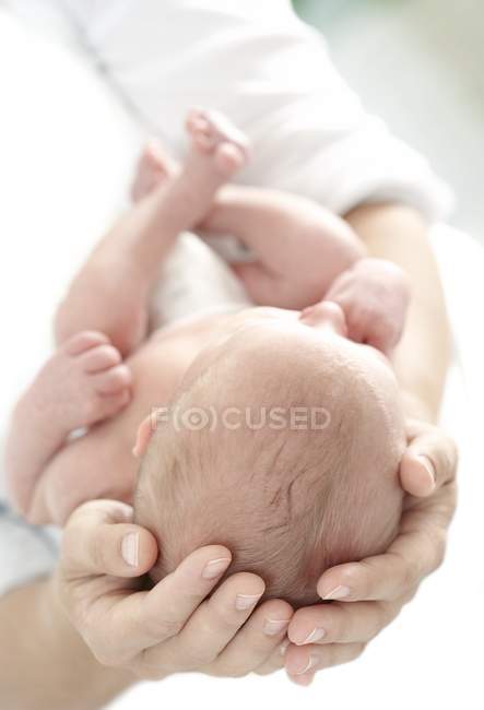 Close-up of mother hands holding newborn baby boy. — Stock Photo