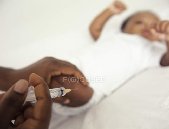 Bébé garçon ayant l'injection dans la jambe . — Photo de stock