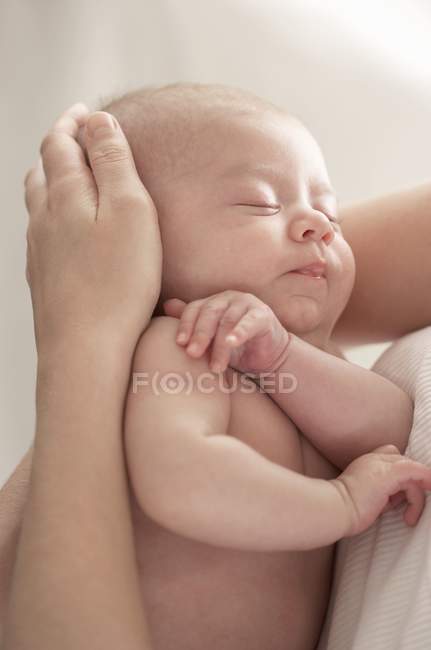 Primo piano del bambino addormentato tra le braccia materne . — Foto stock
