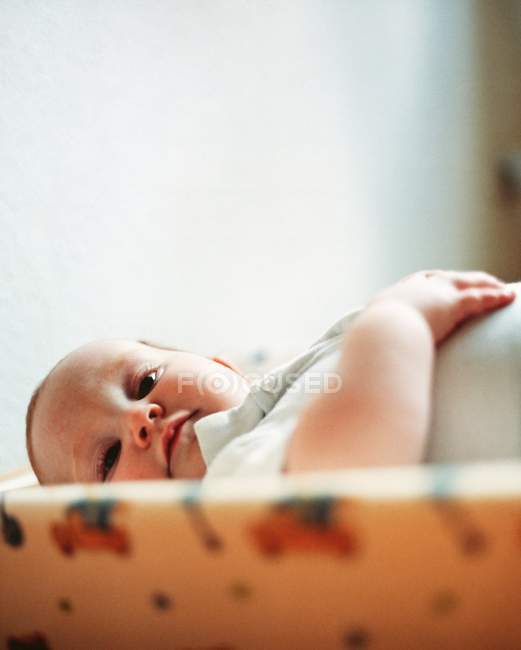 Baby boy lying down in bed. — Stock Photo