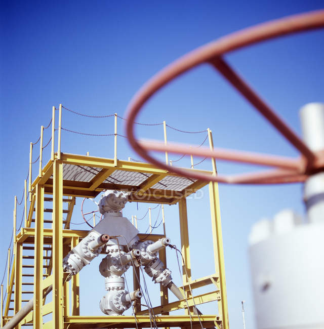 Array of pipes and valves fitted to production wellhead. — Stock Photo