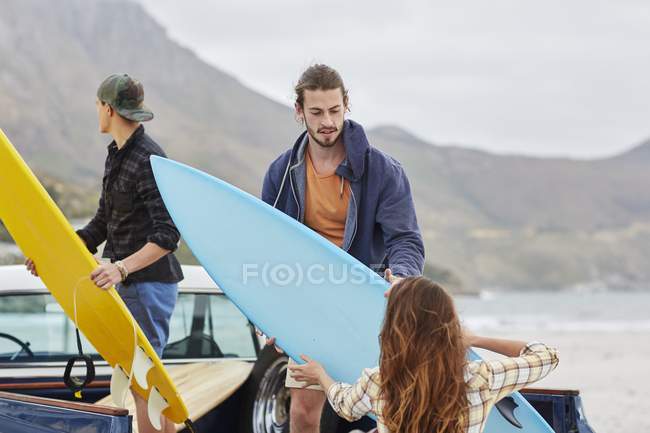 Молода жінка передає дошку для серфінгу чоловікам . — стокове фото