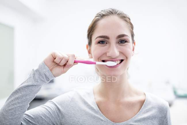 Молода жінка чистить зуби, портрет . — стокове фото
