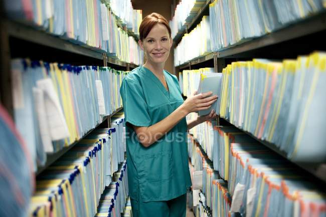 Enfermeira a verificar registos médicos na arrecadação . — Fotografia de Stock