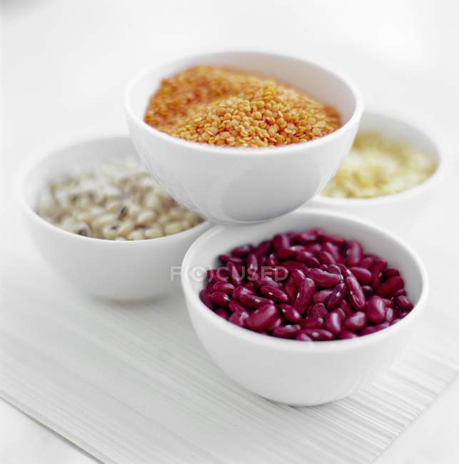 Assorted beans and pulses in white bowls. — Stock Photo