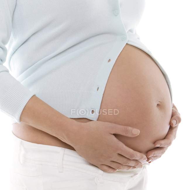Pregnant woman holding abdomen, cropped view. — Stock Photo