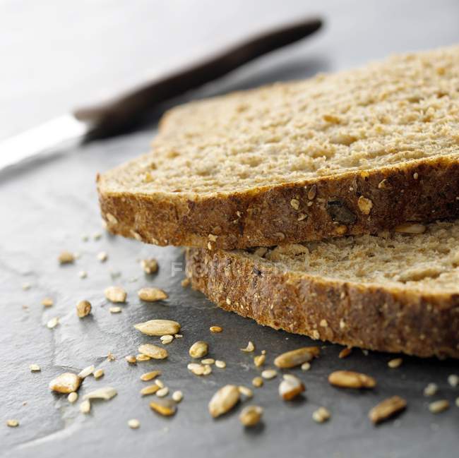 Slices of organic granary bread on table. — Stock Photo