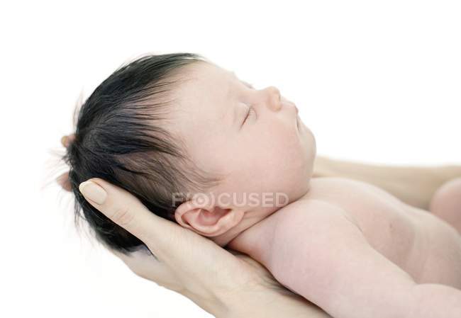 Madre manos sosteniendo bebé recién nacido niña . - foto de stock