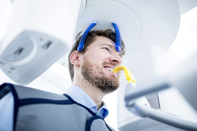 Hombre que tiene rayos X dentales en la clínica - foto de stock