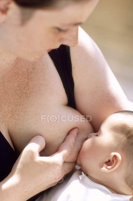 Close-up view of mother breastfeeding infant baby. — Stock Photo