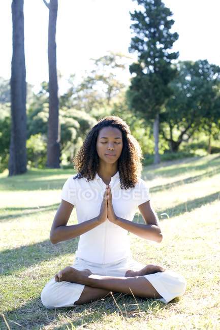 Mujer joven meditando con las manos juntas . - foto de stock