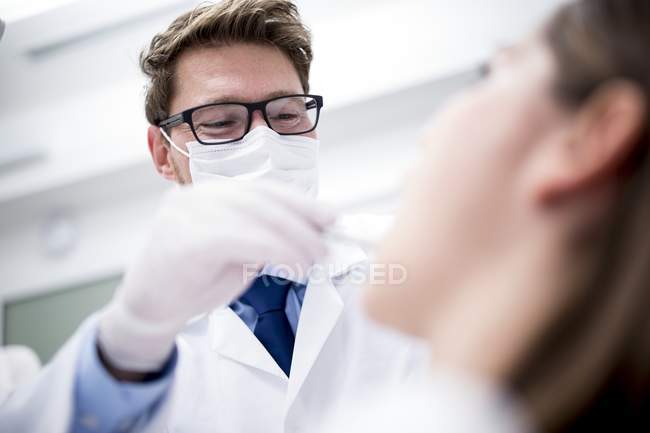 Dentista che esamina i denti del paziente in una clinica dentistica . — Foto stock