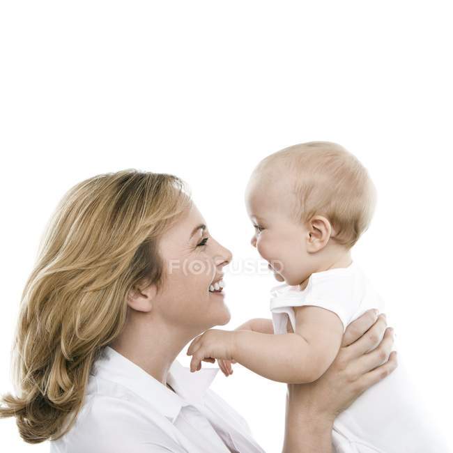 Mother holding infant baby on white background. — Stock Photo